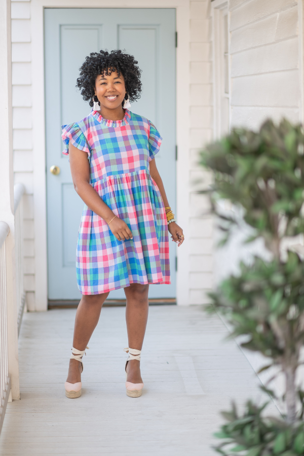 business owner in the cap ruffle sleeve knee length pink blue and green check dress