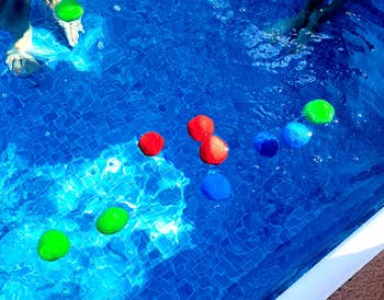reviewer's photo of the water balls floating in a pool
