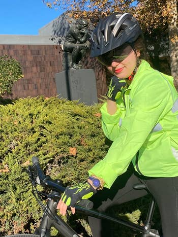 reviewer photo on bike, wearing green and black bike gloves