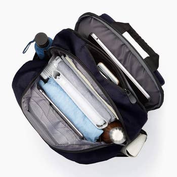 Top view of an open, organized backpack with various compartments storing tech and personal items