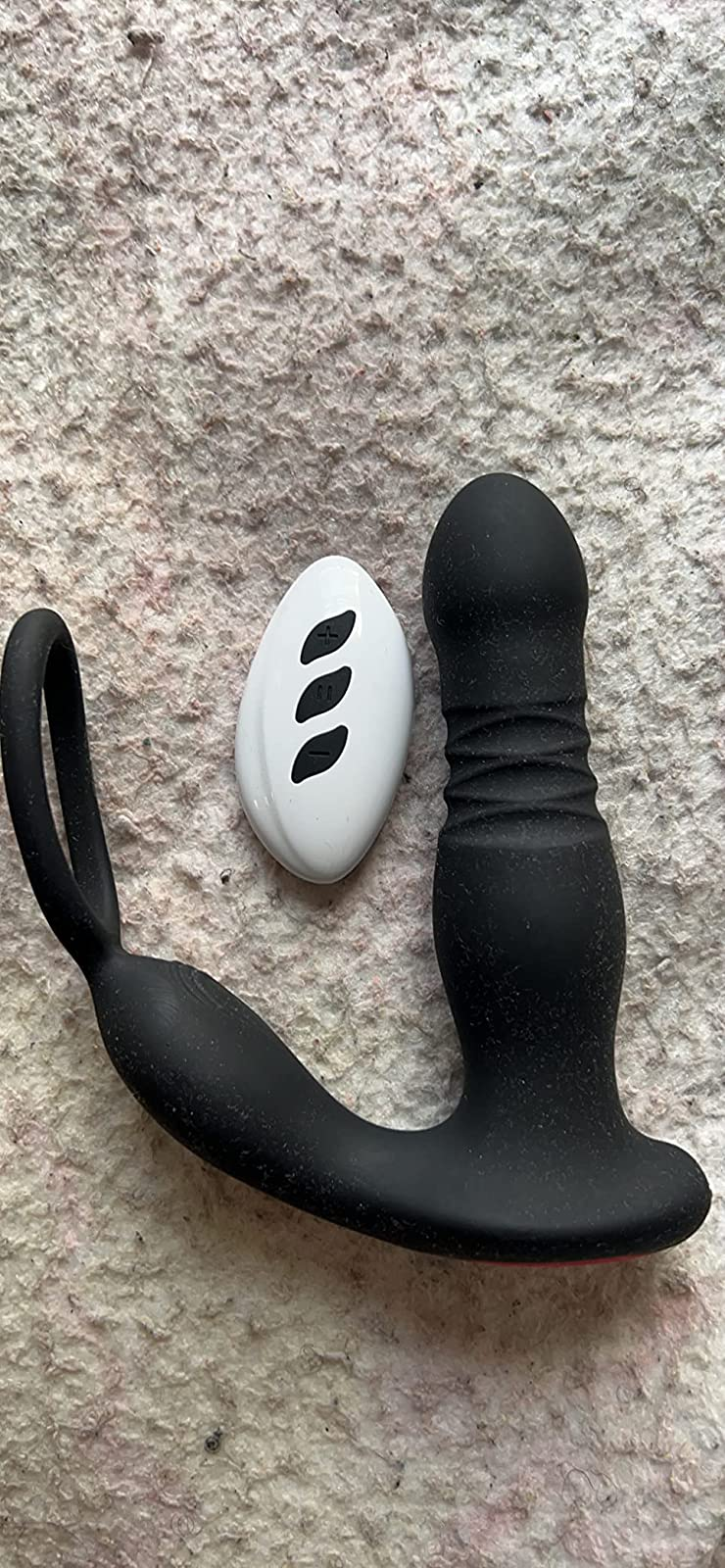 Black prostate vibrator next to white wireless remote