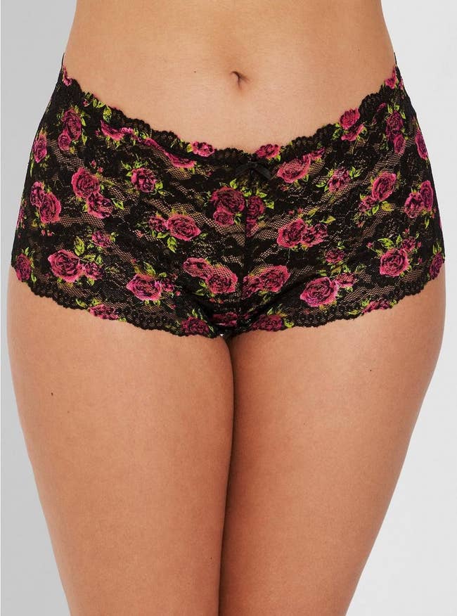 model wearing the black lace underwear with roses all over it