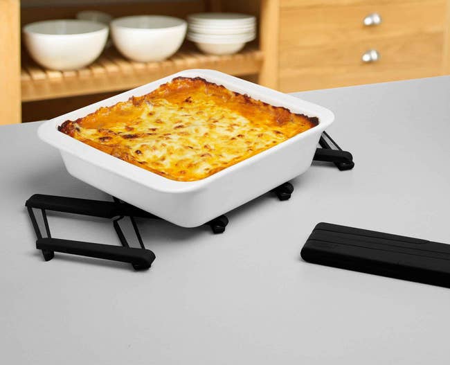 the expandable trivet on a counter with a pan sitting on top