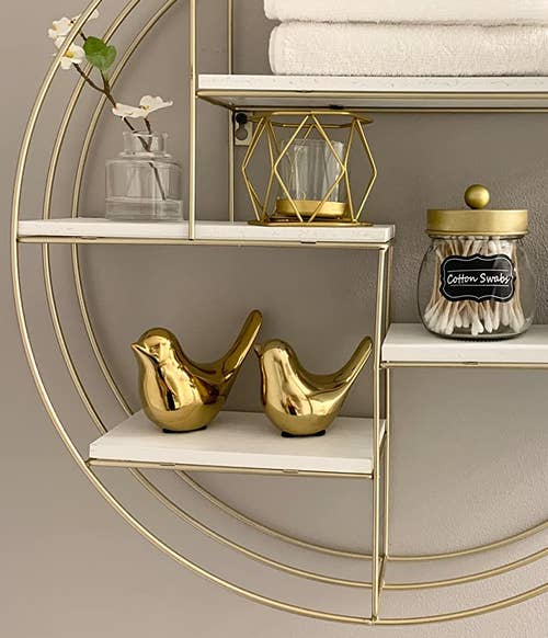 two birds in gold on a shelf