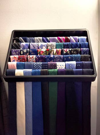 reviewer's black organizer on the wall holding an assortment of colorful neckties 