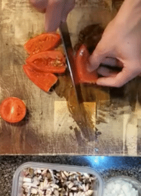gif of reviewer using the knife to thinly slice and chop tomatoes