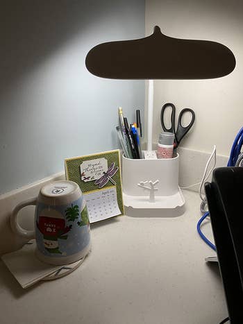 the lamp on a reviewer's office desk with various utensils stored in it
