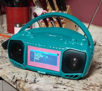 Retro-style teal boombox with a show  surface  connected  a room  countertop
