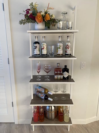 same bookcase with barware, glasses, and wine bottles