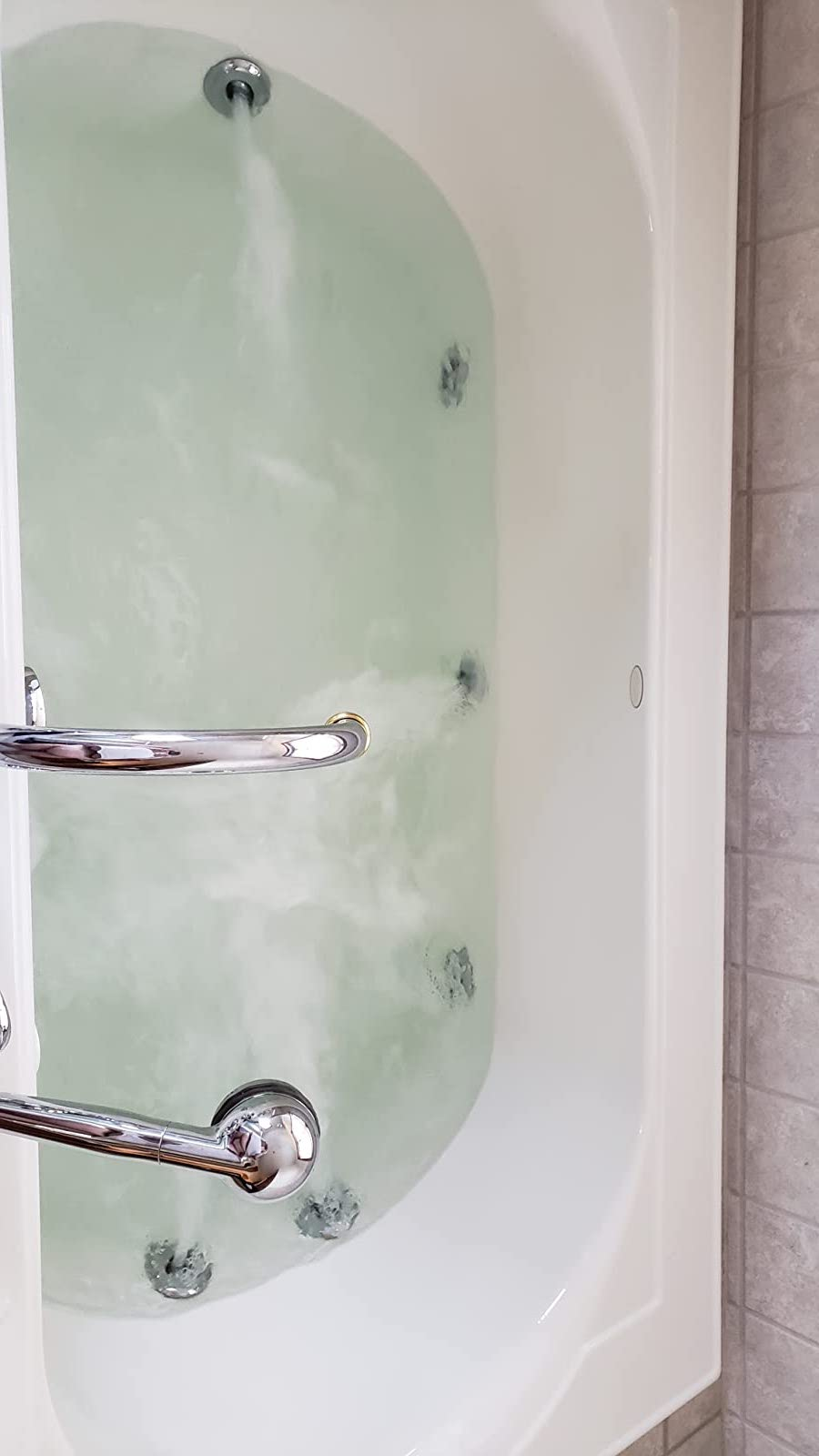 reviewer after photo of the tub filled with perfectly clear water after being cleaned