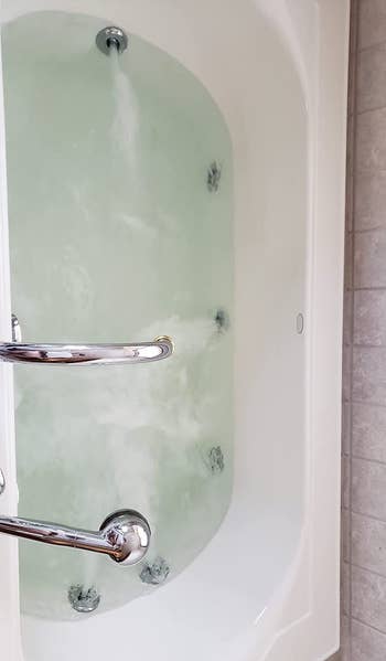 reviewer after photo of the tub filled with perfectly clear water after being cleaned