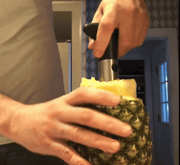 gif of a reviewer using the corer and pulling out the contents of pineapple