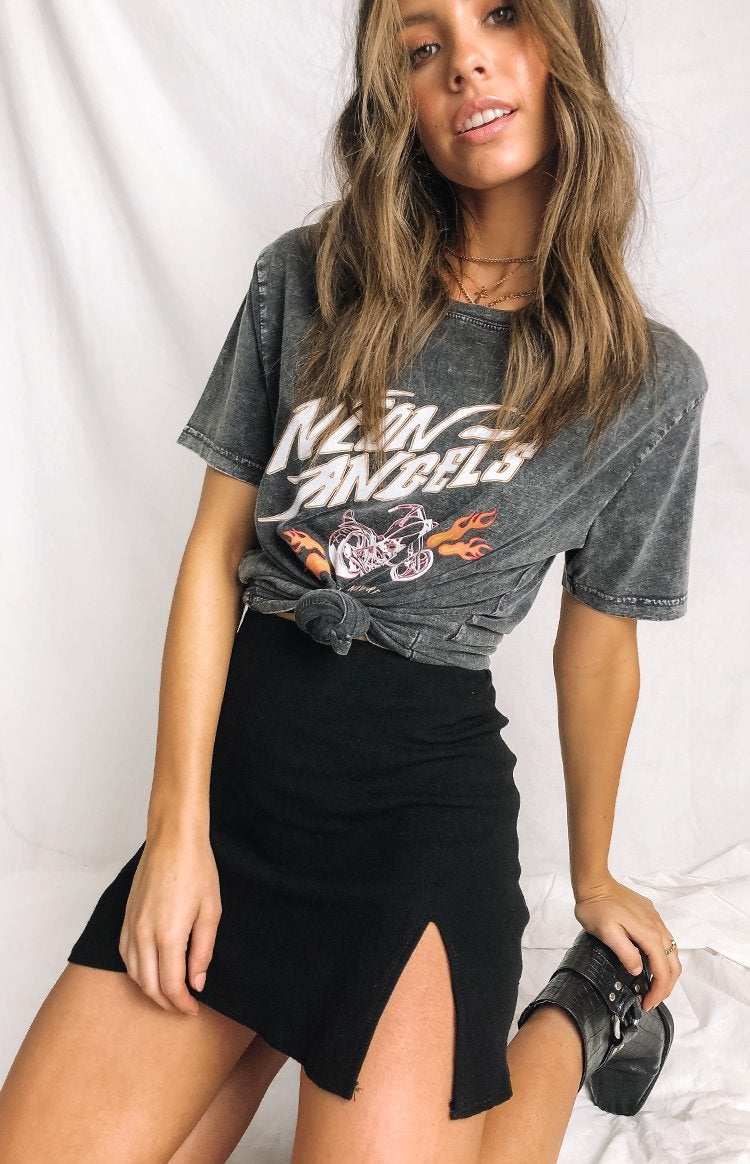 Model is wearing a black mini skirt and graphic T-shirt