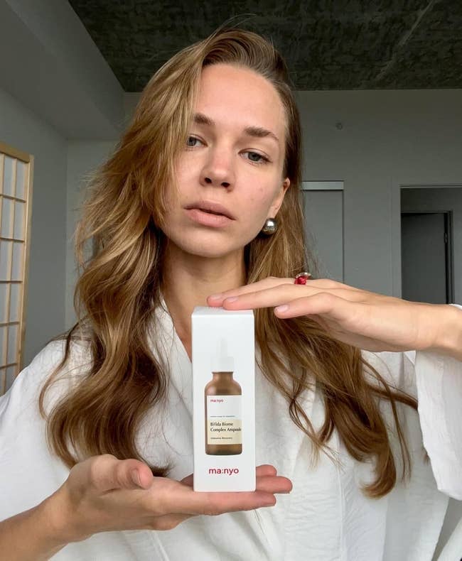 nyo Bifida Ampoule against a minimalist background, wearing a achromatic robe, with agelong hairsbreadth down