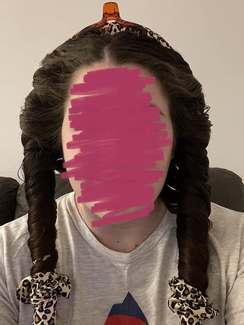 reviewer showing the cheetah print headband on their head with hair wrapped around it