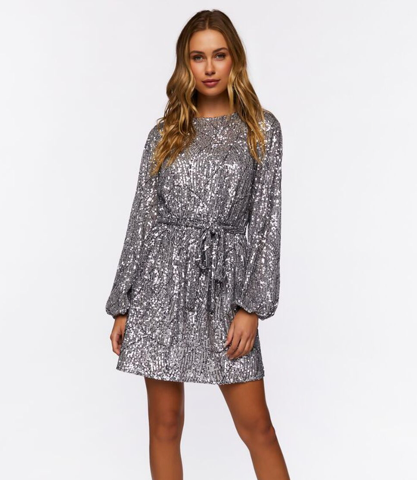 Model is wearing a silver sequined long sleeve dress