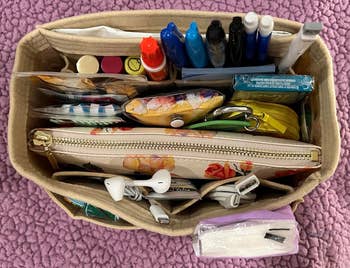 reviewer representation  of insert filled with schoolhouse  supplies, wires, a wallet, and different   items neatly organized