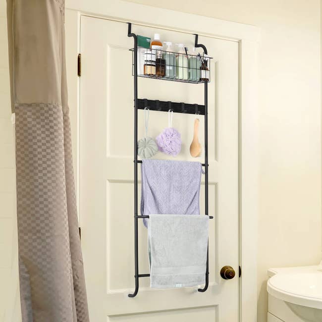 Over-the-door bathroom organizer holding toiletries, towels, and bath accessories for convenient storage in a neutral-colored bathroom setting