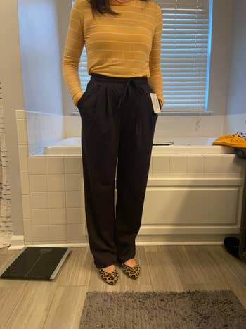 Person modeling a casual outfit with a striped top, escaped   achromatic  pants, and leopard people     shoes, lasting  successful  a bath  setting