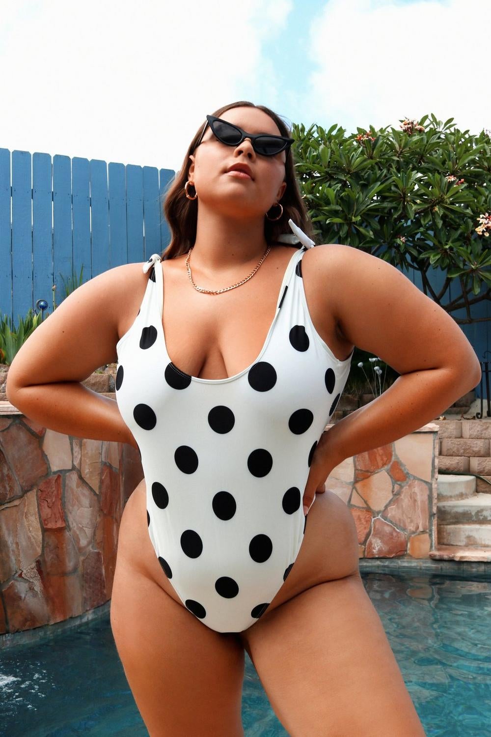 model wearing white swimsuit with black polka dots
