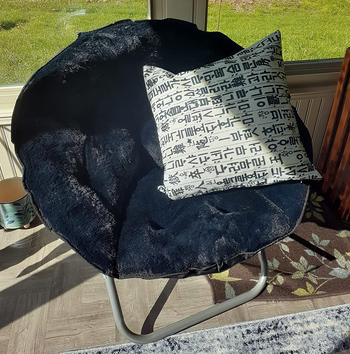 Reviewer image of black saucer chair with black and white throw pillow