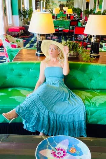 reviewer sitting in hotel lobby wearing dress in blue