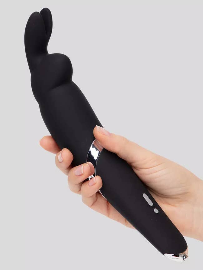 Model holding black rabbit-shaped wand vibrator