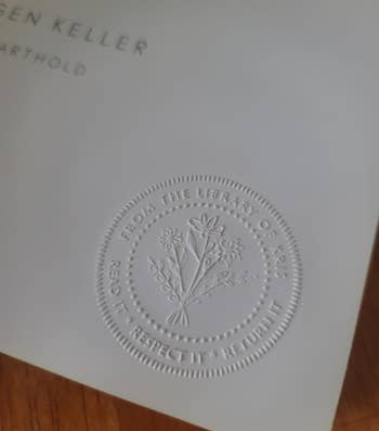Embossed seal on a book cover reads: