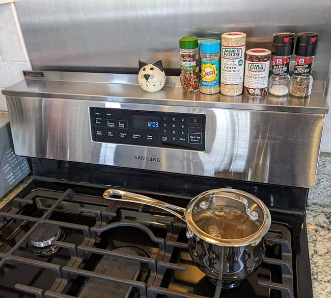 reviewer photo of the magnetic shelf holding seasonings and a timer above a stove