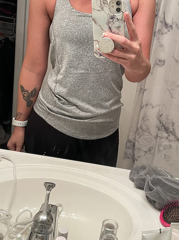 reviewer wearing a gray tank top and black leggings