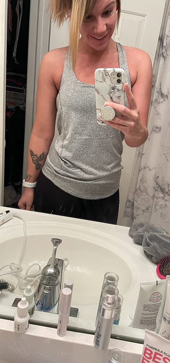 reviewer wearing a gray tank top and black leggings
