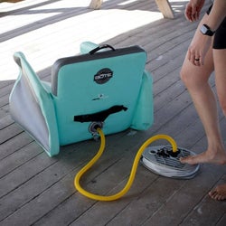 person pumping air into the teal inflatable aero chair