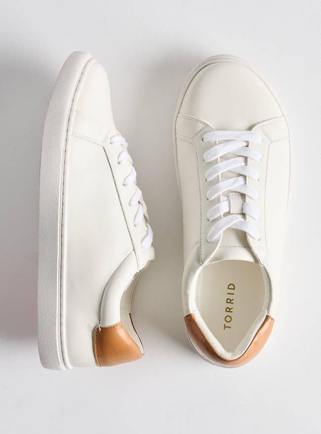 White sneakers with a brownish accent connected the heel, featuring achromatic laces and a sleek design, perfect for casual oregon sporty outfits