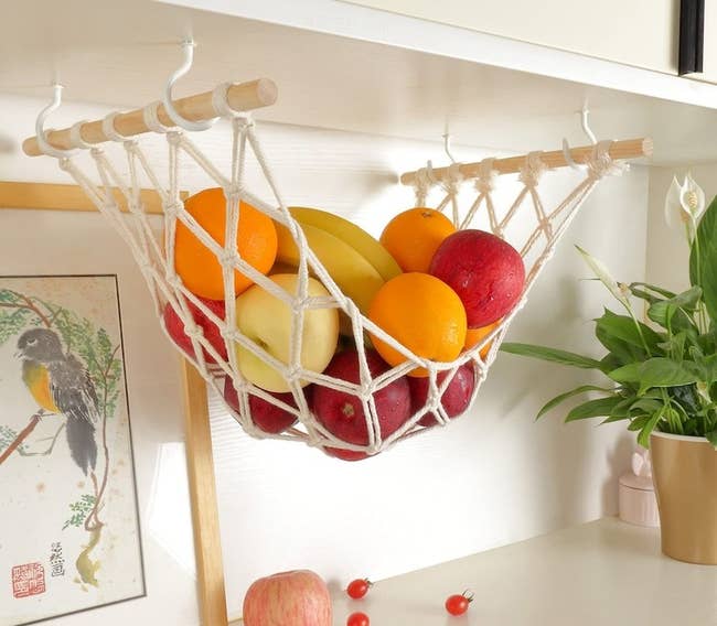 the hammock loaded up with fruit installed under a cabinet 
