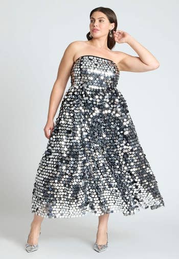 Person successful  a strapless, floor-length, sequined formal  posing confidently