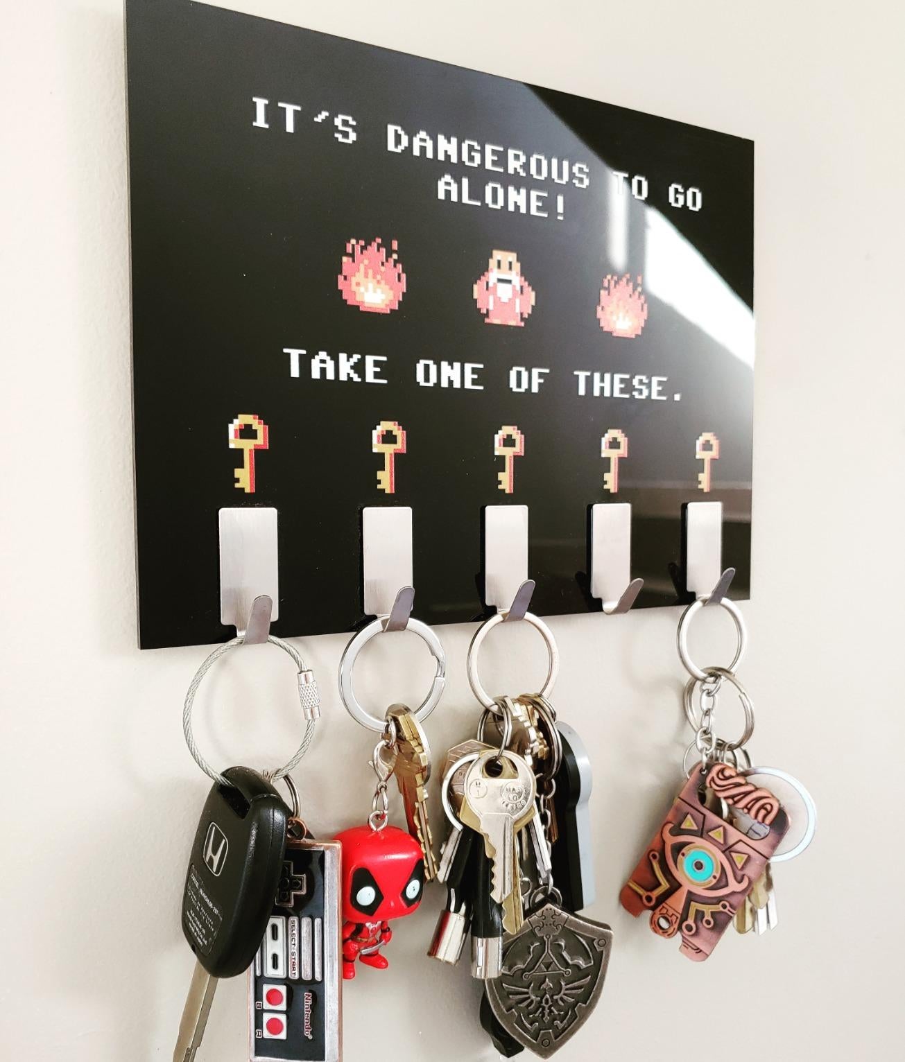 a reviewer photo of the black plaque and keys hanging from the attached hooks 