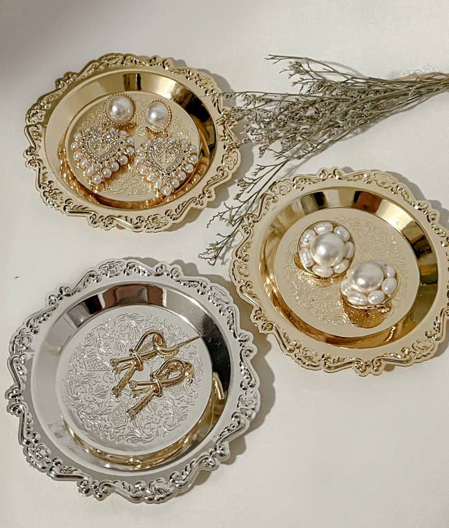 Silver and gold antique-shaped plates with accessories on them