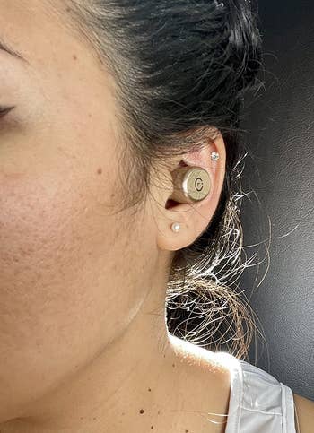 reviewer wearing the rose gold earbud in their ear