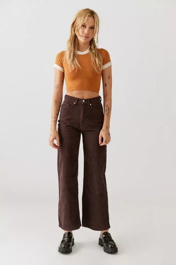 a model wearing brown high waisted corduroy jeans