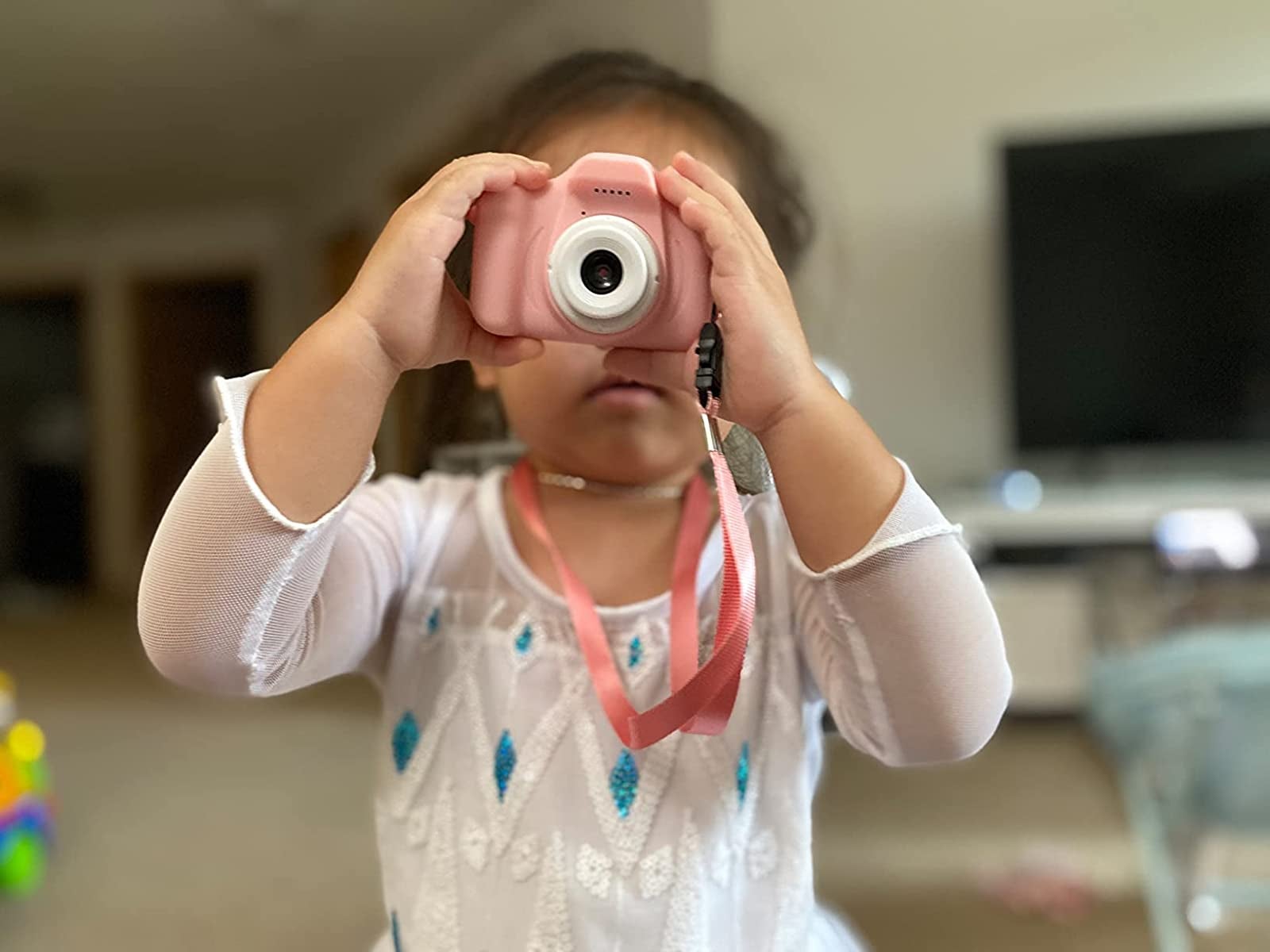 reviewer image of child holding pink camera up to their face
