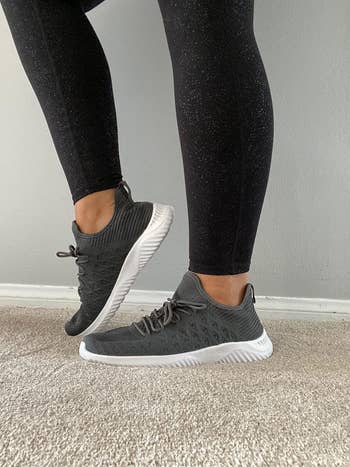 A reviewer wearing the sneakers in gray