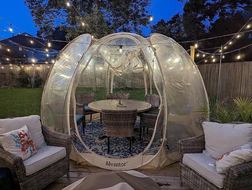 reviewer's bubble tent in their backyard with a dining set inside