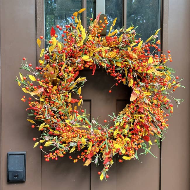 reviewer's fall door wreath with yellow leaves and red berries