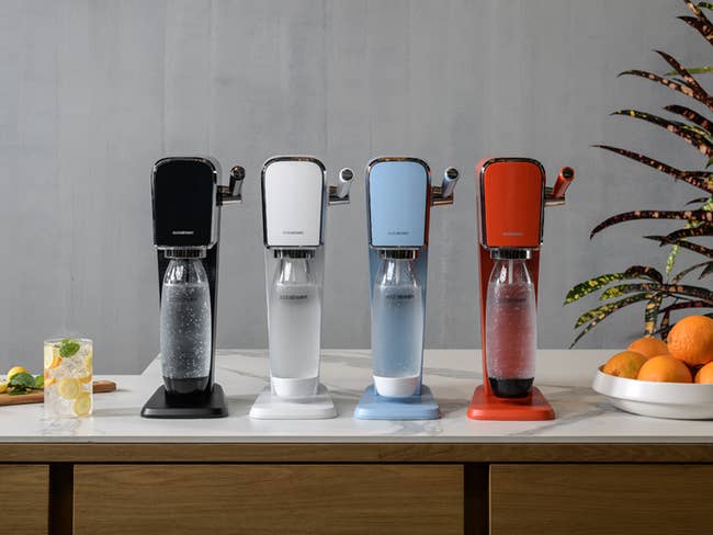 four sodastream makers in black, white, blue, and red