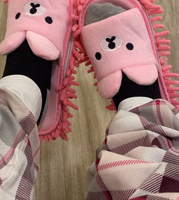 reviewer wearing the pink bear mop slippers on their feet