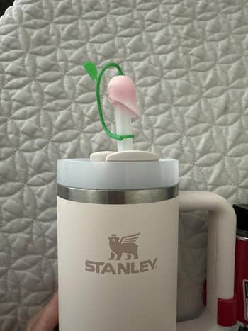 A reusable Stanley tumbler with a detachable rose topper onto the straw