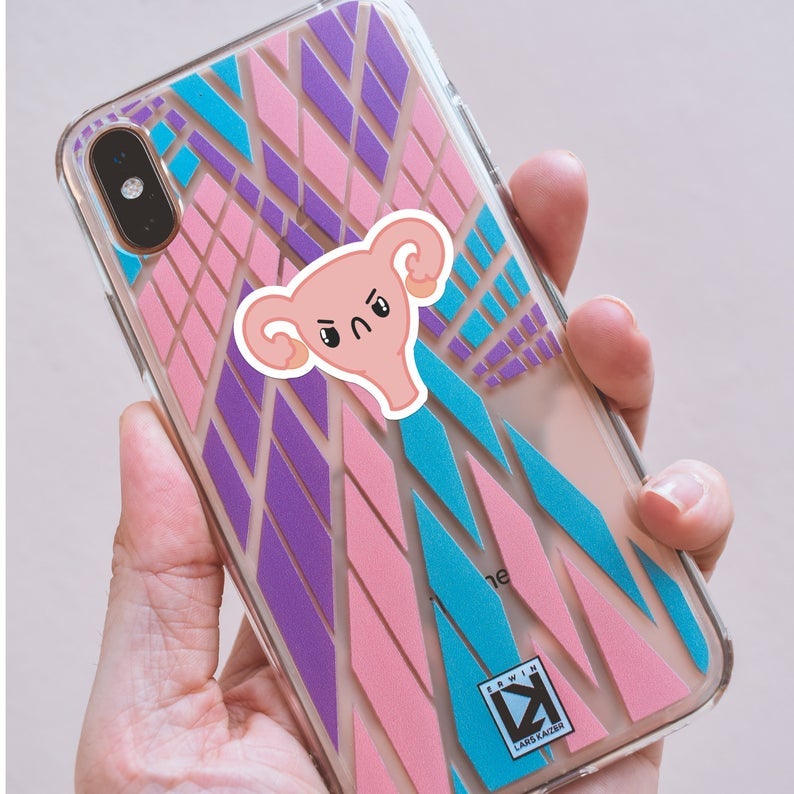 small frowny face uterus sticker on a phone case