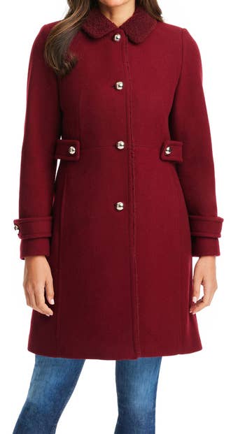 A model wearing the fleece trim coat in red