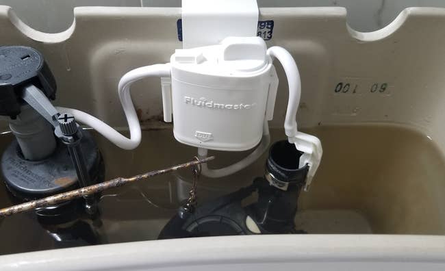 reviewer image of flush 'n sparkle kit in water tank of toilet