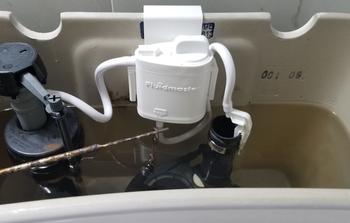 reviewer image of flush 'n sparkle kit in water tank of toilet